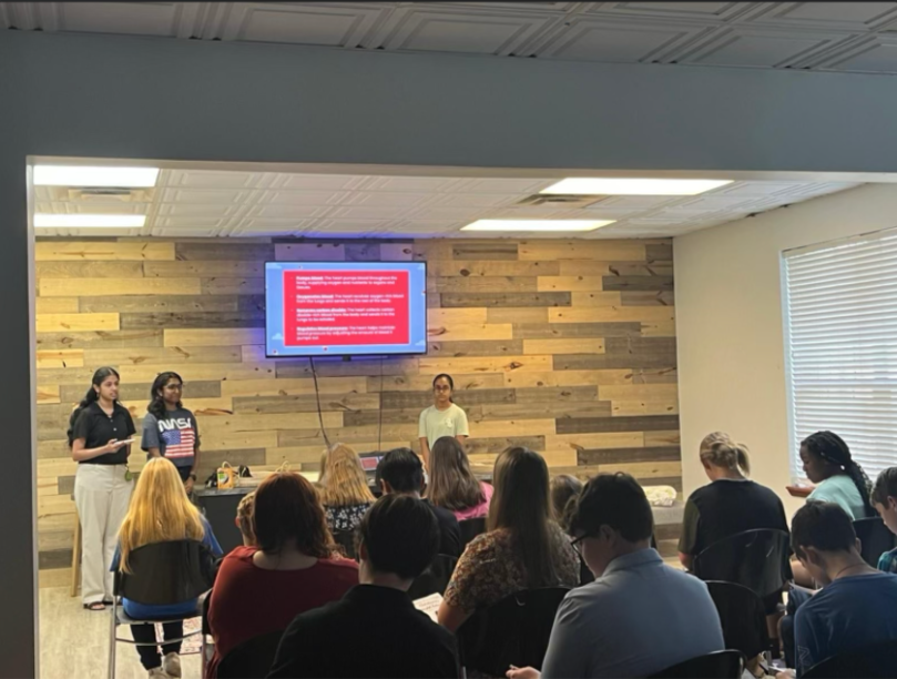Three HFH volunteers lead a workshop for a full room at a community center